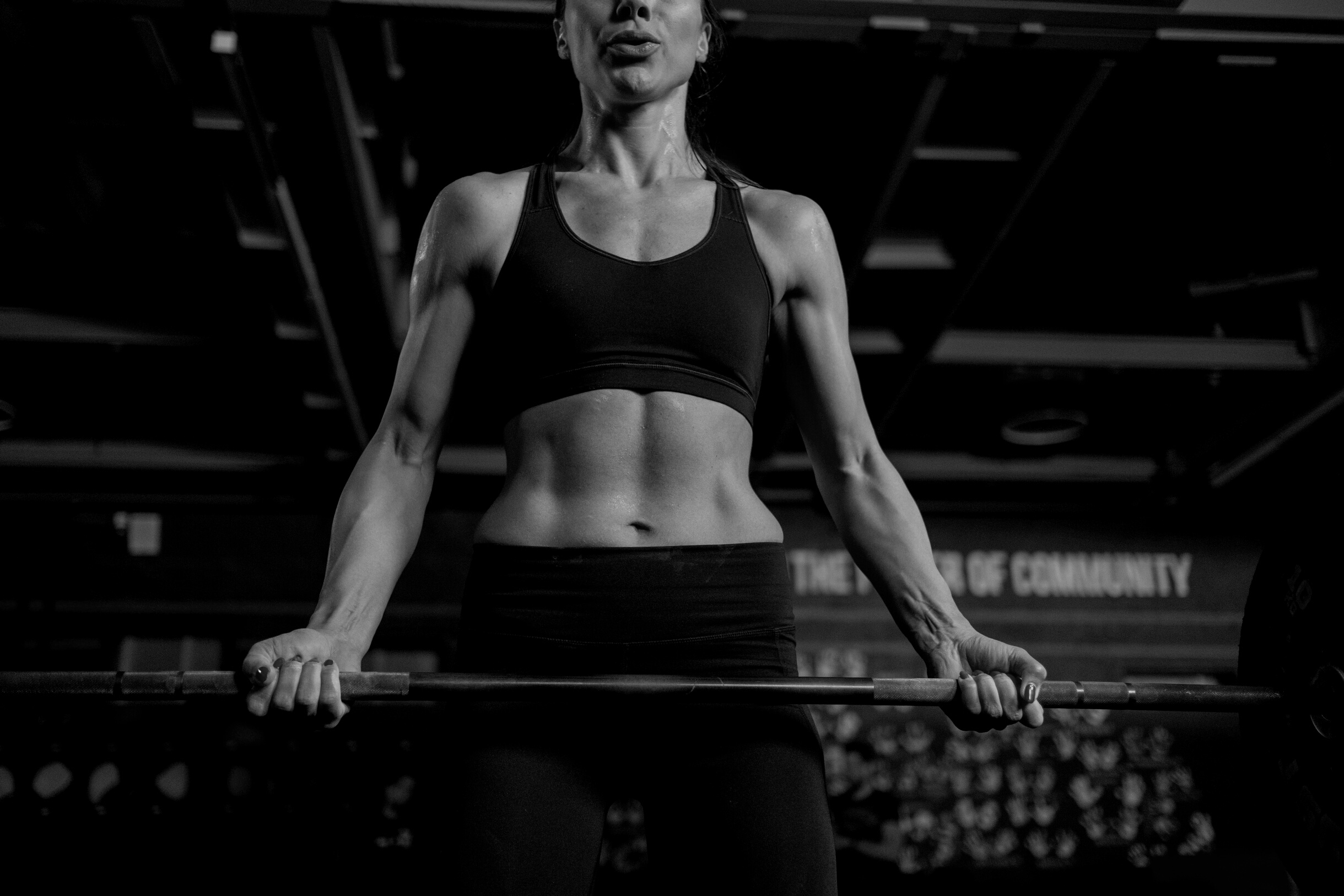 Woman in Black Sportswear Lifting a Barbell